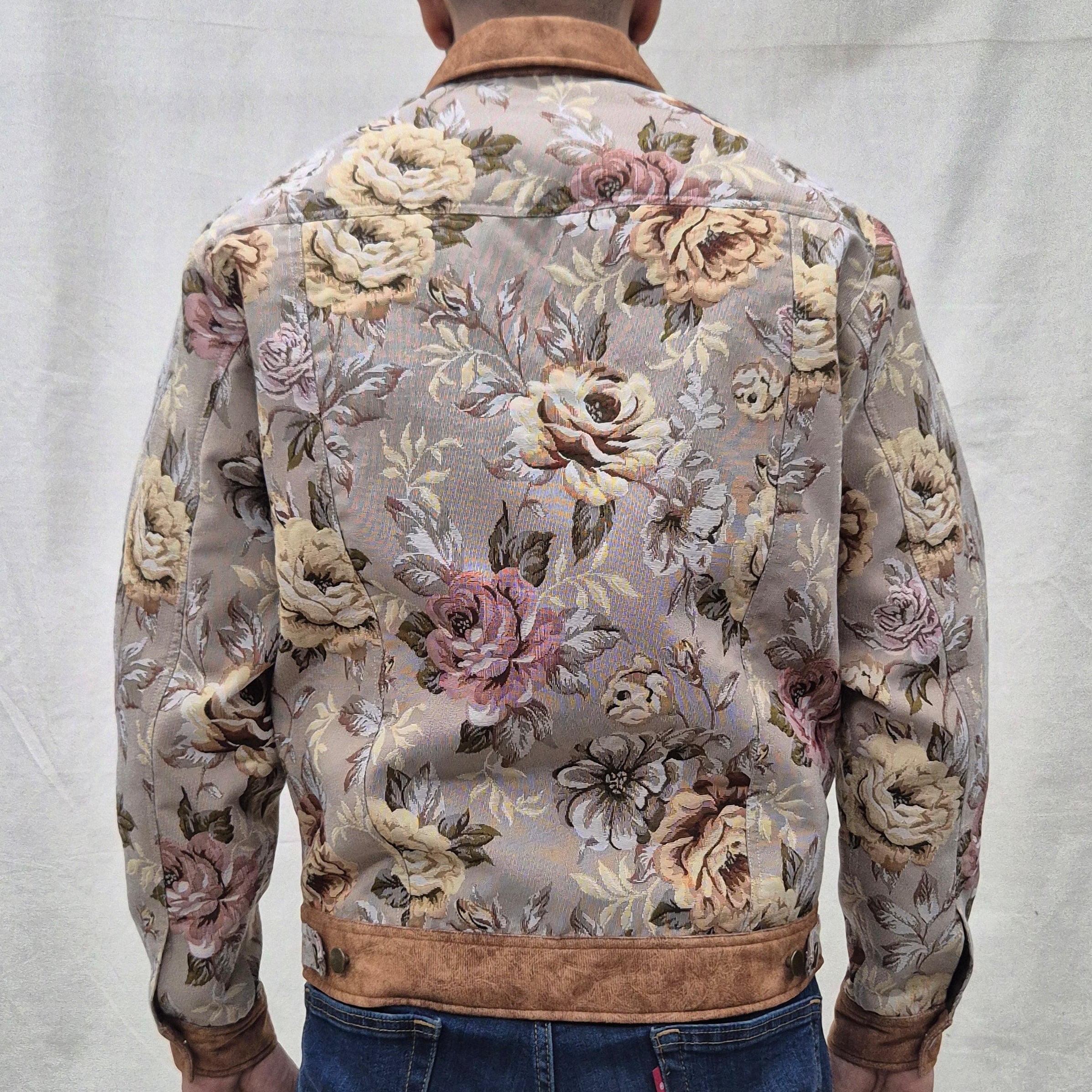 Person wearing a floral-patterned jacket on a plain background